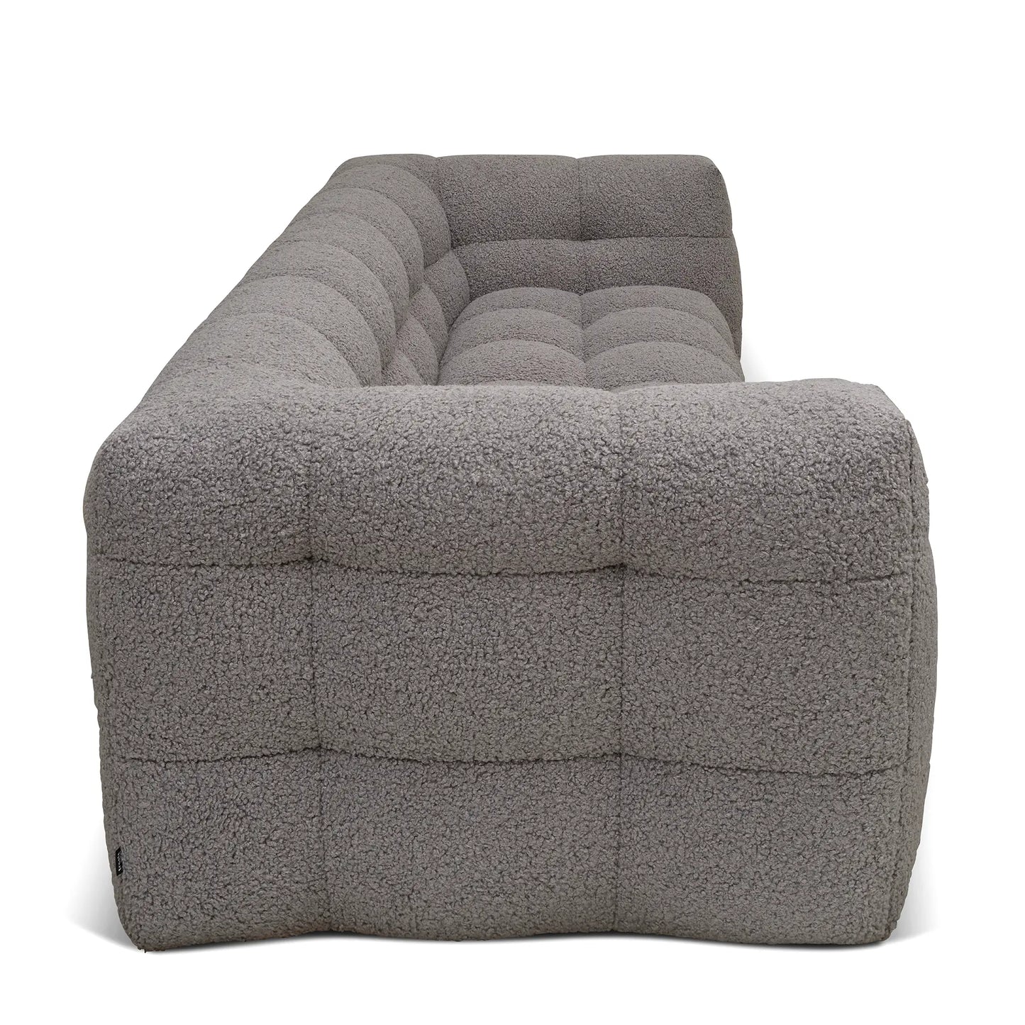 Vy från sidan på en fluffig grå teddysoffa i teddypäls tyg i dansk design