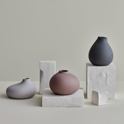 Set om tre vaser i serien Nona stående på olika stenblock
