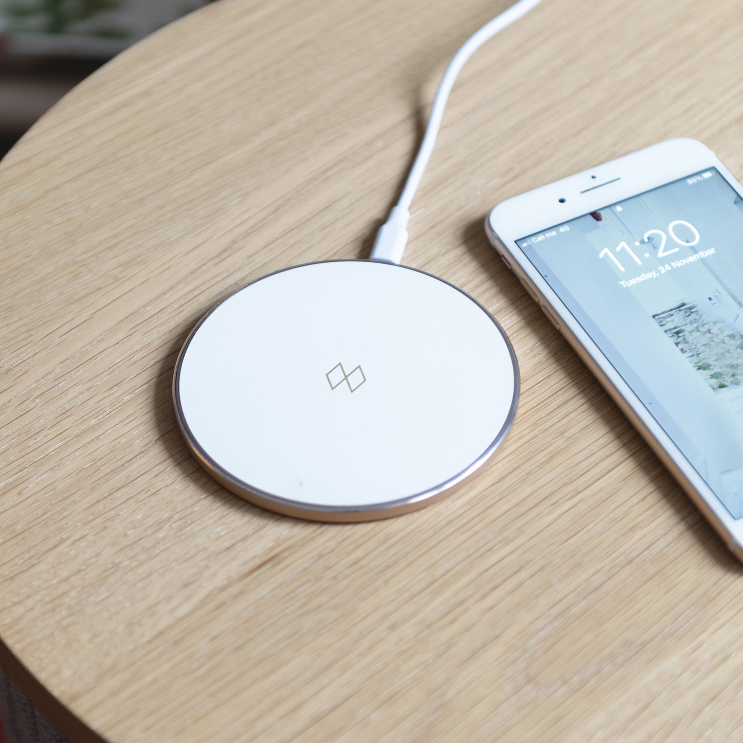 Snygg Qi-laddare för trådlösa enheter såsom en smartphone i vit och roséguld